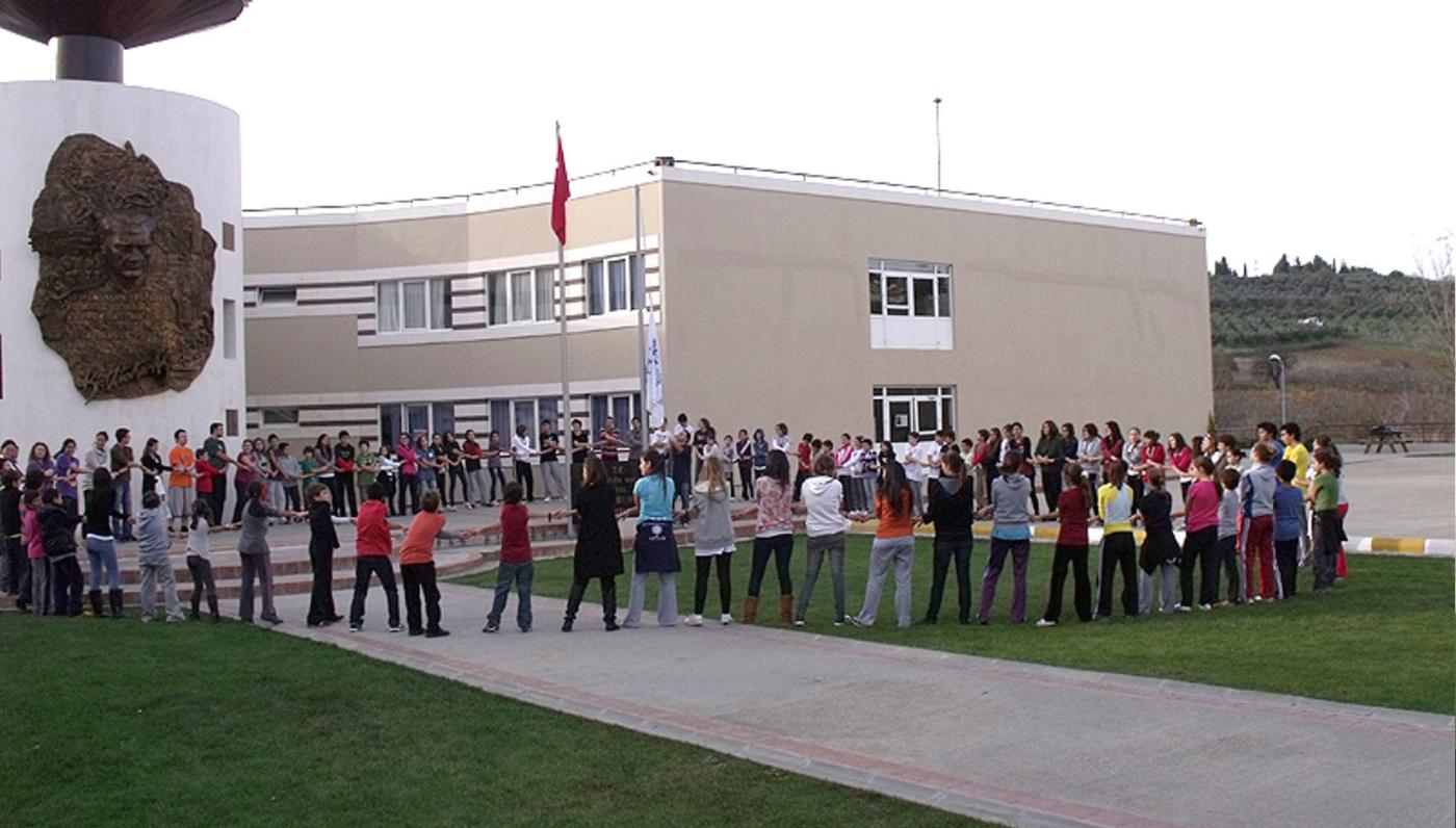 Kampüs bahçesinde el ele vererek çember oluşturan CISV katılımcıları